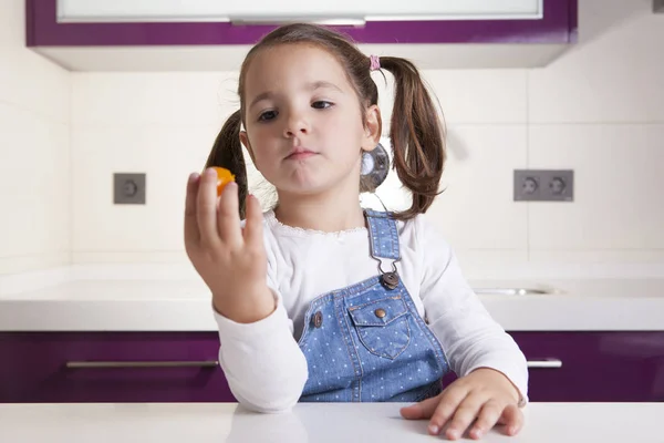 Παρατηρώντας ένα πολύχρωμο κεράσι ντομάτα πριν τη γευστική δοκιμή σε αυτό το μικρό κορίτσι — Φωτογραφία Αρχείου