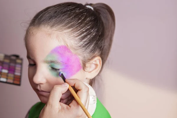 Little cute girl making facepaint before halloween party — Stock Photo, Image