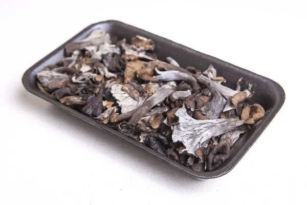 Black polythene tray full of Horn of Plenty mushrooms — Stock Photo, Image