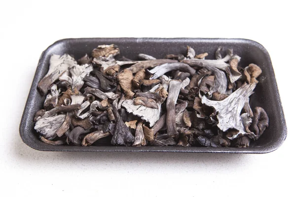 Black polythene tray full of Horn of Plenty mushrooms — Stock Photo, Image