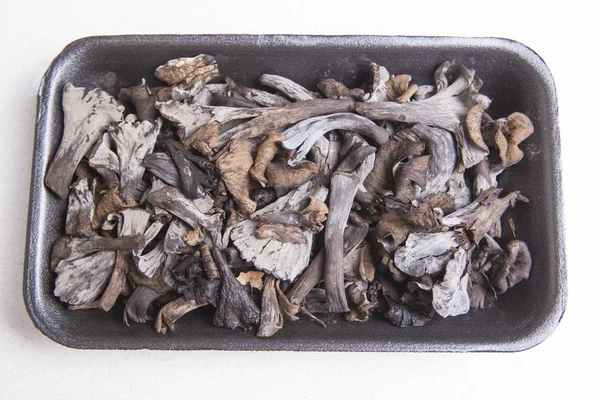 Black polythene tray full of Horn of Plenty mushrooms — Stock Photo, Image