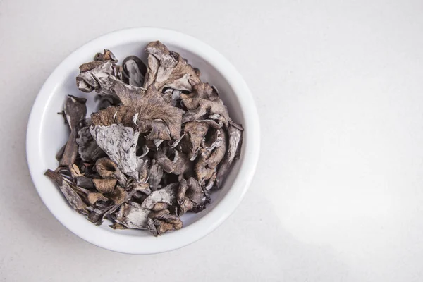 Tigela branca cheia de cogumelos Horn of Plenty — Fotografia de Stock