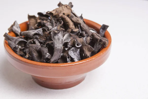 Clay bowl full of Horn of Plenty mushrooms — Stock Photo, Image