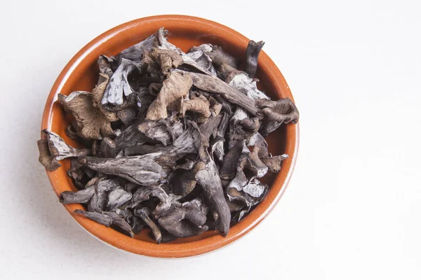 Clay bowl full of Horn of Plenty mushrooms — Stock Photo, Image