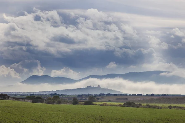 Scenery spannmål fält och liten stad med slottet mellan th — Stockfoto