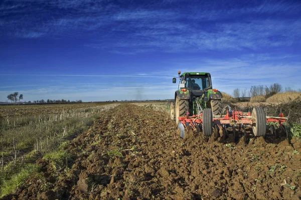 Paysage agricole avec tracteur agricole préparant le sol — Photo