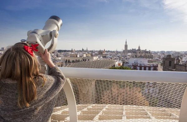 Little girl with telescope pointing to old town landmarks over M — Stock Photo, Image