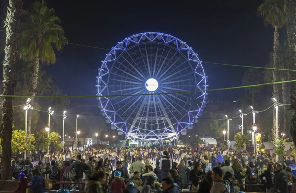 Människor besöka julmarknaden med pariserhjul och is — Stockfoto