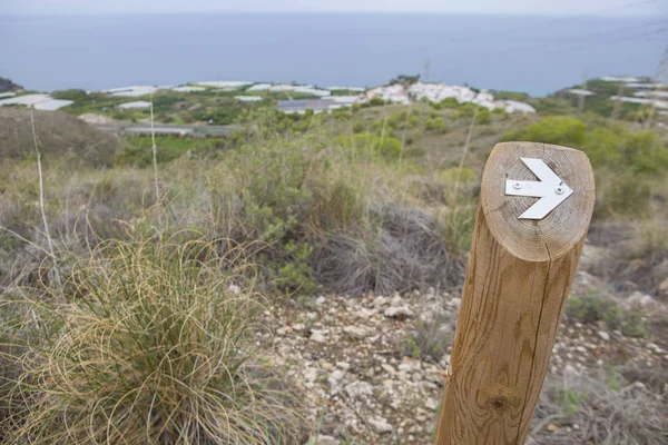 Hiking sign at trekking path beside the coast