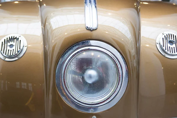 Detalhe central do farol em um carro clássico goldenrod — Fotografia de Stock