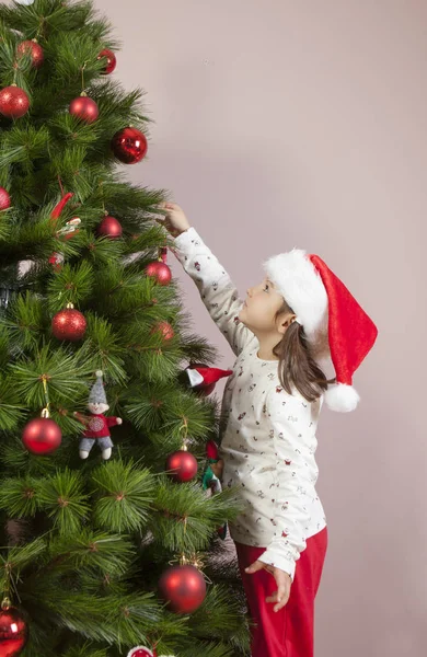 小女孩用红色的球装饰圣诞树 — 图库照片