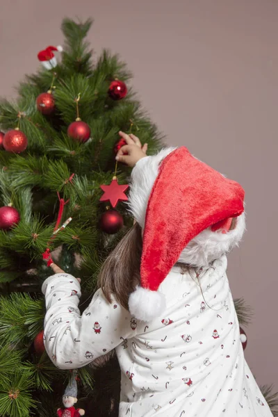 小女孩用红色的球装饰圣诞树 — 图库照片