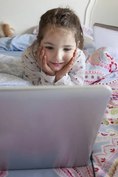 Dziewczynka, oglądanie filmów z laptopa. Ona wygląda zabawy — Zdjęcie stockowe