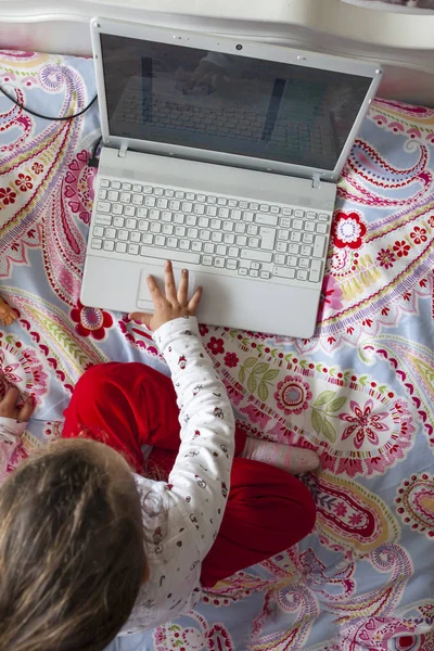 Bambina seduta a letto e giocare online — Foto Stock
