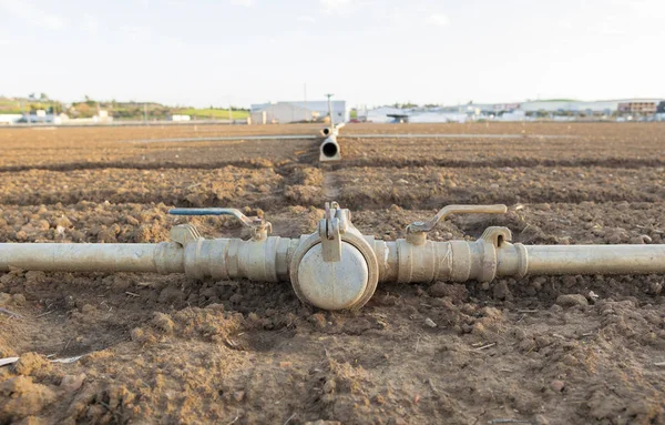 Irrigation metal pipes connections on recently seeded field — Stock Photo, Image