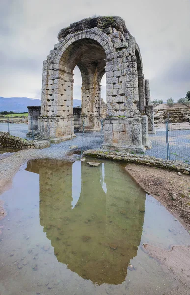 Römischer Bogen von Caparra reflektiert über Pfütze, Ceceres, Spanien — Stockfoto