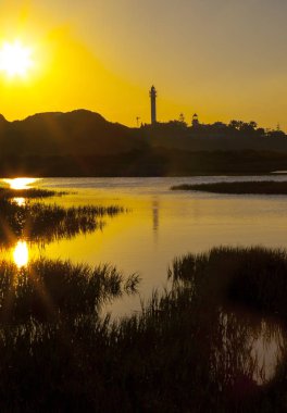 El Rompido deniz feneri ve gündoğumu Marinada bataklık üzerinden