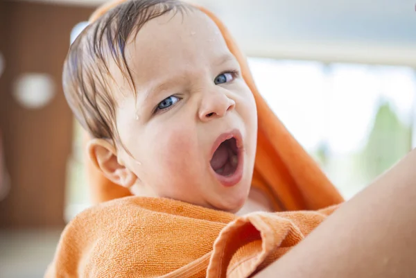 Pojke i orange handduk gäspningar efter dopp — Stockfoto