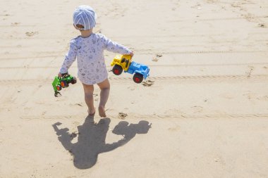 Oyuncaklarla Sahilde yürüyüş erkek bebek