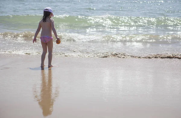 Küçük kız plaj kıyıda oynamaya — Stok fotoğraf