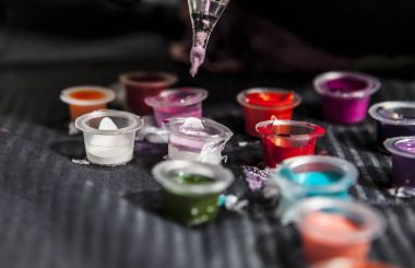 Dövme kalemi makine üzerinde küçük bardak renkli mürekkep tam