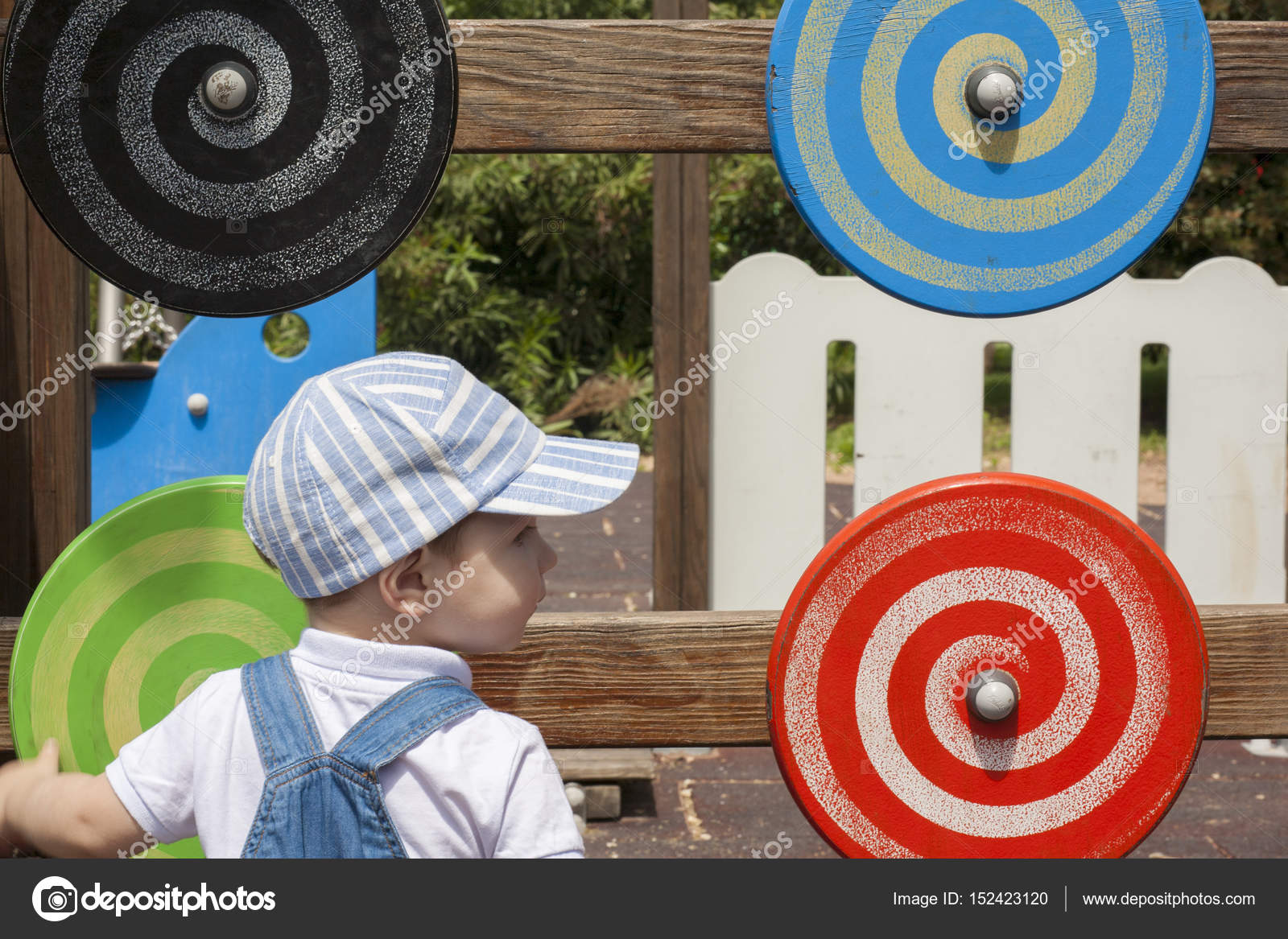 2 anni che gioca con disco a spirale di legno al parco giochi per bambini —