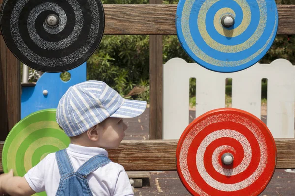 2 year-old boy playing with wooden spiral disc at playground — Stock Photo, Image