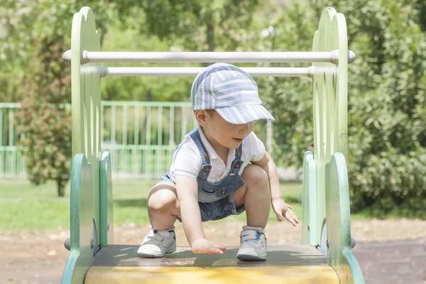 Menino no topo do controle deslizante. Conceito de equilíbrio — Fotografia de Stock