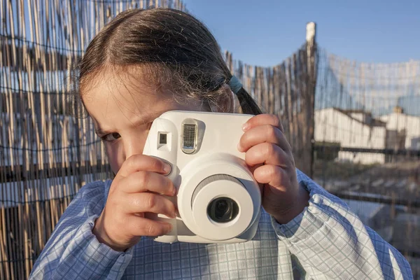 Ładna dziewczynka szczęśliwy z aparat fotograficzny natychmiastowy obraz — Zdjęcie stockowe