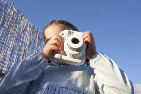 Linda niña feliz con cámara de fotos instantánea — Foto de Stock