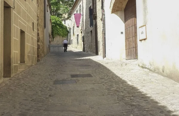Hombre mayor caminando en una calle medieval en Trujillo —  Fotos de Stock