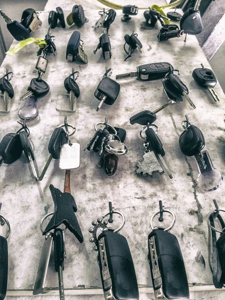 Car keys hanging on hooks at mechanic workshop stand — Stock Photo, Image