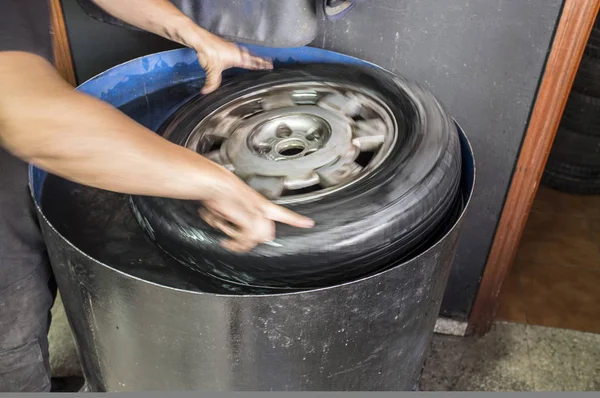 Las manos mecánicas del coche se hunden en el tanque de agua el neumático —  Fotos de Stock