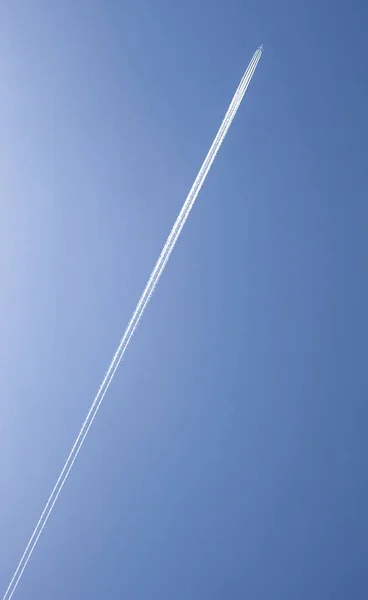 Groot wit vliegtuig met vier motoren over blauwe bewolkte hemel — Stockfoto