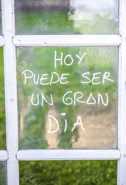 วลีที่มองโลกในแง่ดีที่เขียนบนแว่นตาหน้าต่างเก่าในภาษาสเปน — ภาพถ่ายสต็อก