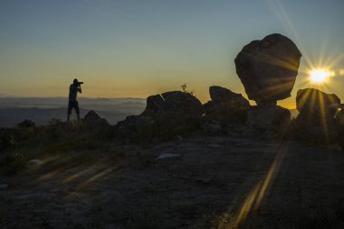 Dağı yükselen güneş çekim bir fotoğrafçı silüeti