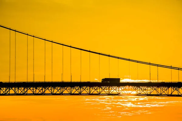 Lastbil korsning hängande bron vid solnedgången — Stockfoto