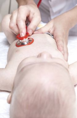Çocuk doktoru yeni doğan bebek çocuk stetoskop ile inceliyor.