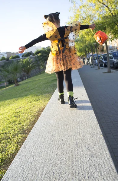 Klein meisje in halloween kostuums spelen in het park — Stockfoto