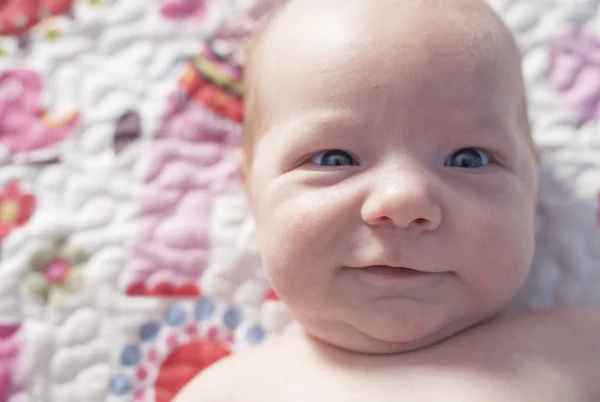 Niño recién nacido sonriendo en la cama —  Fotos de Stock