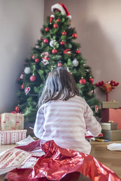 小女孩在圣诞树下打开礼物 — 图库照片