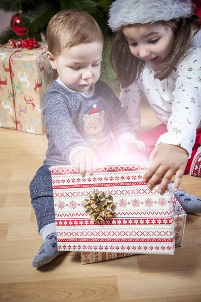 小兄弟在圣诞树旁打开礼物 — 图库照片