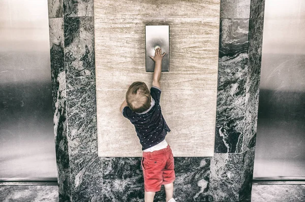 Yürümeye başlayan çocuk arama asansör düğmesine — Stok fotoğraf