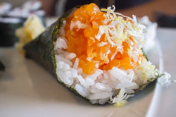 Kegelförmiges Lachs-Temaki-Sushi auf weißem Teller — Stockfoto