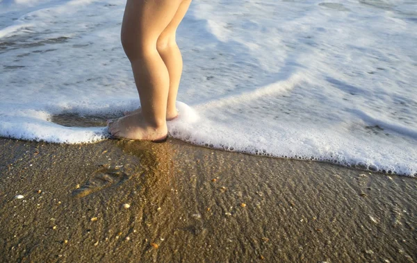 Niño jugando en la espuma del mar en la playa Islantilla, España —  Fotos de Stock