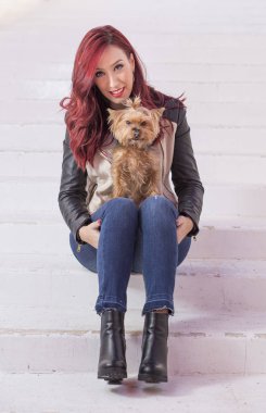 Köpeği ile beyaz arka plan üzerinde oturan moda güzel kadın