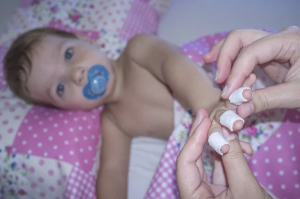 Chlapeček ukazuje ovázanou prsty před trpí domácí — Stock fotografie