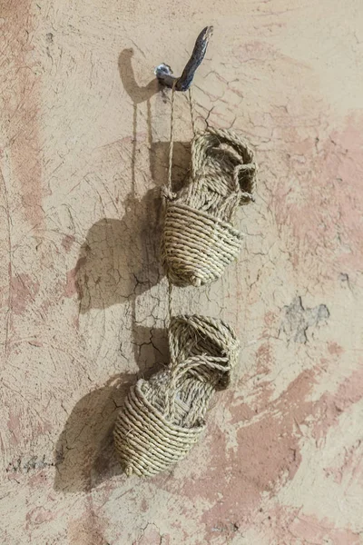 壁の釘からぶら下がっている先史時代のエスパルト サンダル。Reconstructi — ストック写真