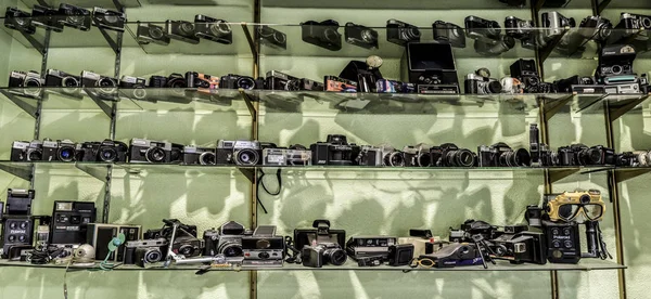Usty üveg polcok tele van régi film vintage kamerák — Stock Fotó