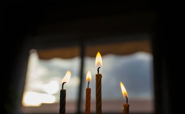 Cuatro velas de cumpleaños en la parte superior de un pastel sobre la ventana oscura cielo azul — Foto de Stock
